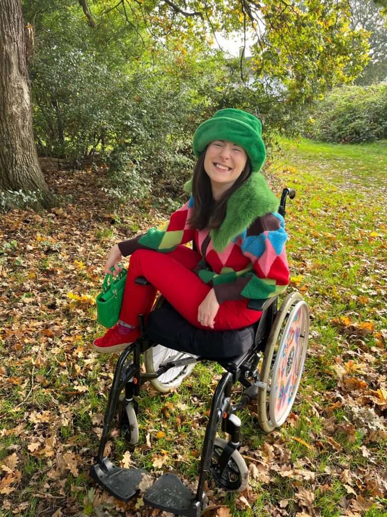 Rebecca, a white woman with brown hair is sitting in her wheelchair